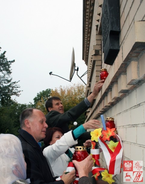 Konsul generalny RP w Grodnie Andrzej Chodkiewicz stawia wraz z działaczami ZPB znicz pod tablicą pamiątkową na Domu Polskim